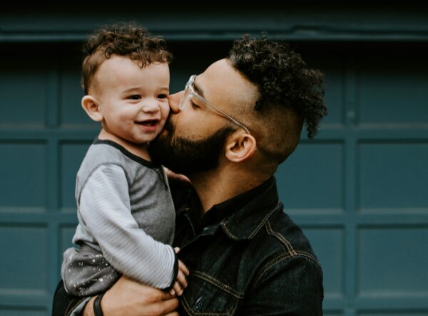 Happy father kisses a baby